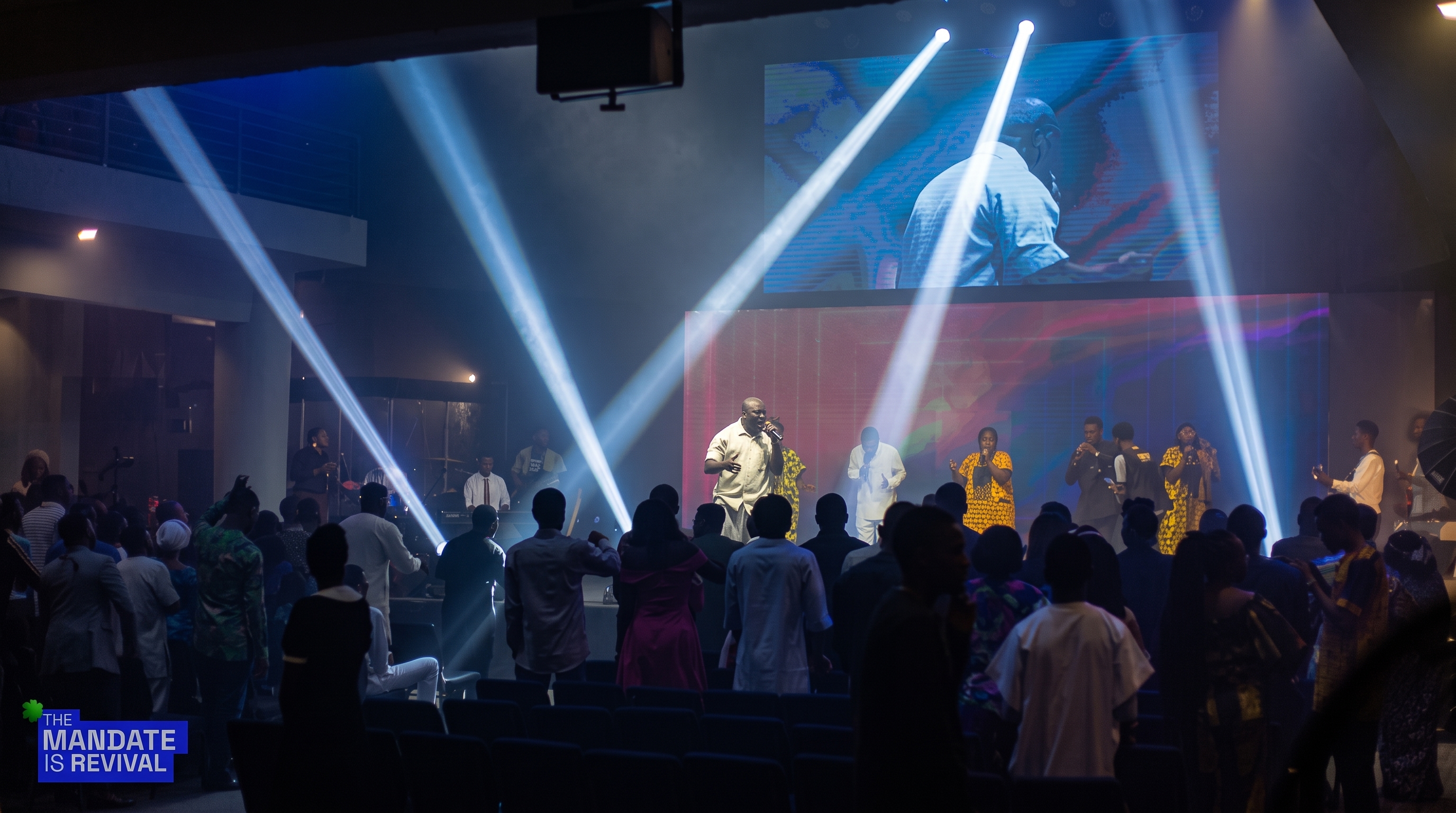 Wide view of Samuel Folabi, the choir and band leading a congregation in worship